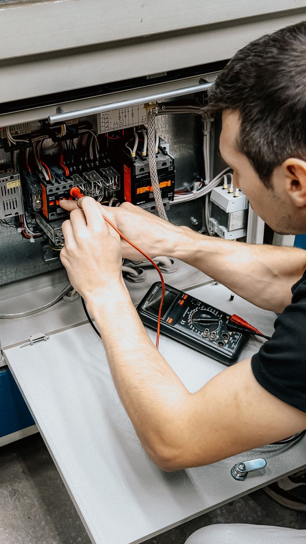 Electrician testing a switchboard with a multimeter