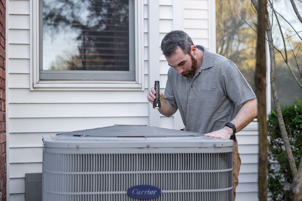 HVAC technician servicing an outdoor heat pump unit